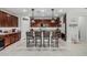 Beautiful kitchen features dark wood cabinets, stainless steel appliances, and a large island with barstool seating at 14419 W El Cortez Pl, Surprise, AZ 85387