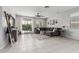 A comfortable living room features a large couch, ceiling fan, tile flooring, and natural light from the backyard at 14419 W El Cortez Pl, Surprise, AZ 85387