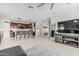 Open-concept living room with kitchen, tile floors, island seating, and modern decor at 14419 W El Cortez Pl, Surprise, AZ 85387
