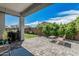 Covered patio featuring beautiful paver flooring, outdoor seating, and lush backyard views at 14419 W El Cortez Pl, Surprise, AZ 85387