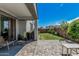 Serene covered patio with brick pavers, outdoor seating, and a view of the landscaped backyard at 14419 W El Cortez Pl, Surprise, AZ 85387