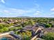 Expansive aerial view of a residential community with mountain views in the distance and backyard pools in view at 15716 W Sheridan St, Goodyear, AZ 85395