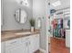 Well-lit bathroom with white cabinetry and an open door to a spacious walk-in closet at 15716 W Sheridan St, Goodyear, AZ 85395