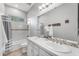 Bright bathroom featuring double sinks with white tile counters and decorative tile accents at 15716 W Sheridan St, Goodyear, AZ 85395