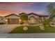 Charming single-story home with stone accents, a two-car garage, manicured lawn, and desert landscaping at 15716 W Sheridan St, Goodyear, AZ 85395