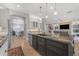 Open concept kitchen featuring a large island with sink and dishwasher, flowing to living room at 15716 W Sheridan St, Goodyear, AZ 85395