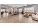 Open-concept living room flowing into a dining area, featuring ample seating and natural light at 15716 W Sheridan St, Goodyear, AZ 85395