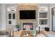Inviting living room featuring a stone fireplace, built-in shelving, and access to the outdoor patio at 15716 W Sheridan St, Goodyear, AZ 85395