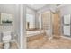Beautiful main bathroom with a soaking tub and walk-in shower featuring glass block accents at 15716 W Sheridan St, Goodyear, AZ 85395