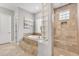 Luxurious main bathroom featuring a soaking tub and walk-in shower with glass block accents at 15716 W Sheridan St, Goodyear, AZ 85395