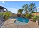 Backyard pool featuring rock waterfall and stone surround, complemented by vibrant landscaping at 15716 W Sheridan St, Goodyear, AZ 85395