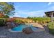 Inviting backyard pool featuring a rock waterfall and lounge chairs for relaxing by the water at 15716 W Sheridan St, Goodyear, AZ 85395