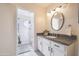 Stylish bathroom showcasing a white vanity, a round mirror, and a beautifully tiled walk-in shower at 18843 N 45Th Ave, Glendale, AZ 85308