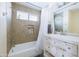 Well-lit bathroom featuring tiled shower with niche, white vanity, and modern fixtures at 18843 N 45Th Ave, Glendale, AZ 85308