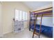 Cozy bedroom with a bunk bed, storage, and natural light from the shuttered window at 18843 N 45Th Ave, Glendale, AZ 85308