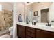 Well-lit bathroom with double sinks, vanity, and tiled shower at 198 N Nevada Way, Gilbert, AZ 85233