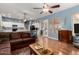 Open-concept living area with wood floors, ceiling fans, and access to the kitchen, perfect for modern living and entertaining at 198 N Nevada Way, Gilbert, AZ 85233