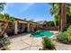 Backyard with a sparkling pool, lush plants and towering palm trees at 198 N Nevada Way, Gilbert, AZ 85233