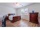Cozy bedroom with hardwood floors, a ceiling fan, and a large window providing natural light at 21277 E Cherrywood Dr, Queen Creek, AZ 85142