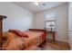 Cozy bedroom featuring a window, ceiling fan, wood-look floors, and neutral paint at 21277 E Cherrywood Dr, Queen Creek, AZ 85142