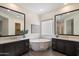 Bright bathroom with a soaking tub, dual vanities, and wood-look tile flooring at 22842 E Via Las Brisas --, Queen Creek, AZ 85142