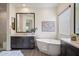 Modern bathroom featuring a soaking tub, a large mirror, and sleek dark cabinets at 22842 E Via Las Brisas --, Queen Creek, AZ 85142