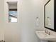 Bathroom with white pedestal sink, black framed mirror and bright natural light from the window at 22842 E Via Las Brisas --, Queen Creek, AZ 85142