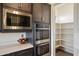Close-up of stainless steel appliances and pantry storage within the designer kitchen at 22842 E Via Las Brisas --, Queen Creek, AZ 85142