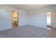 Comfortable carpeted bedroom with a bathroom entrance and access to an outdoor patio at 24184 W Gibson Ln, Buckeye, AZ 85326