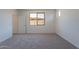 Bright bedroom featuring neutral walls, carpet, and a window view at 24184 W Gibson Ln, Buckeye, AZ 85326