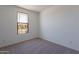 Bright bedroom featuring neutral walls, carpet, and a large window at 24184 W Gibson Ln, Buckeye, AZ 85326