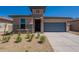 Charming single-story home featuring brick accents, a two-car garage, and low maintenance desert landscaping at 24184 W Gibson Ln, Buckeye, AZ 85326