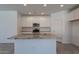 Spacious kitchen featuring a large granite island, white cabinetry, stainless steel appliances, and ample counter space at 24184 W Gibson Ln, Buckeye, AZ 85326