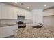 Bright kitchen with white cabinets, stainless steel appliances, a granite countertop, and a subway tile backsplash at 24184 W Gibson Ln, Buckeye, AZ 85326