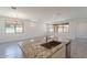 Open-concept kitchen featuring a large island with granite countertops, a sink, and natural light from the windows at 24184 W Gibson Ln, Buckeye, AZ 85326