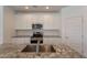 Modern kitchen featuring white cabinets, granite countertops, stainless steel appliances, and a stylish backsplash at 24184 W Gibson Ln, Buckeye, AZ 85326