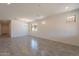Open-concept living room with tile flooring, a modern chandelier, and plenty of natural light from large windows at 24184 W Gibson Ln, Buckeye, AZ 85326
