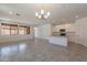 Large open living area with modern lighting, tile floors, and seamless integration with a well-equipped kitchen space at 24184 W Gibson Ln, Buckeye, AZ 85326