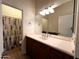 Bathroom featuring a large vanity, mirror, and walk-in shower area with a geometric patterned curtain at 2427 W Desert Hills Estate Dr, Phoenix, AZ 85086
