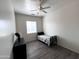 Clean bedroom featuring modern gray laminate floors and a ceiling fan at 2427 W Desert Hills Estate Dr, Phoenix, AZ 85086