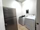 Convenient laundry area including a stainless refrigerator, washer, and dryer at 2427 W Desert Hills Estate Dr, Phoenix, AZ 85086