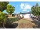 A serene backyard featuring a lush lawn, mature trees, and a charming patio area, ideal for enjoying outdoor living at 2435 E Jensen St, Mesa, AZ 85213