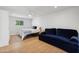 Cozy bedroom with a bed, ceiling fan, accent rug, and comfortable blue velvet sofa at 2435 E Jensen St, Mesa, AZ 85213