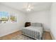 Sunny bedroom with a metal frame bed, wood floors, and large window with shutters at 2435 E Jensen St, Mesa, AZ 85213