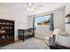 Bright Bedroom with a crib, accent chair, and a storage bookcase with room to grow at 2435 E Jensen St, Mesa, AZ 85213