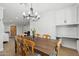 Bright dining room featuring a wooden table, seating for six, stylish chandelier, and fresh white paint at 2435 E Jensen St, Mesa, AZ 85213