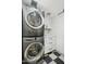 Functional laundry room featuring a stacked washer and dryer and storage cabinets at 2435 E Jensen St, Mesa, AZ 85213
