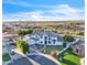 Stunning aerial view of a white two-story home with lush landscaping and a beautiful mountain view at 2662 N Chestnut Cir, Mesa, AZ 85213