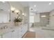 Bright bathroom boasts double vanity, stylish mirrors, and a luxurious, tiled walk-in shower at 2662 N Chestnut Cir, Mesa, AZ 85213