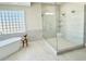 Elegant bathroom showcases a glass-enclosed shower and modern tub with travertine tile at 2662 N Chestnut Cir, Mesa, AZ 85213